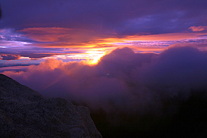 The sun rises between a gap in the clouds