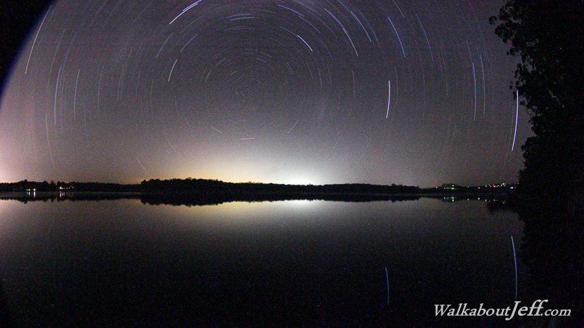 Star trails over still water